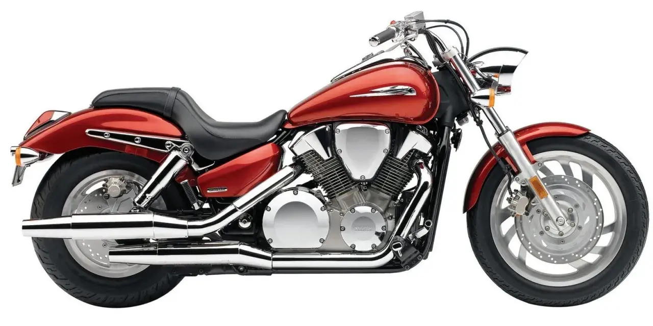 Czerwony motocykl Honda VTX 1300 z chromowanymi elementami i potężnym silnikiem V-twin.