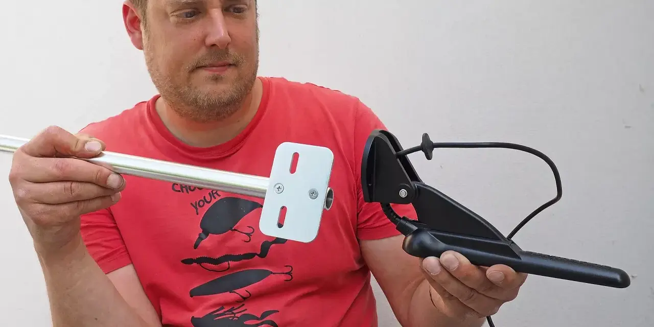 Mann hält Aluminiumrohr und Echolotgeber. Idee: Echolotgeberstange selber bauen für Angeltrip.