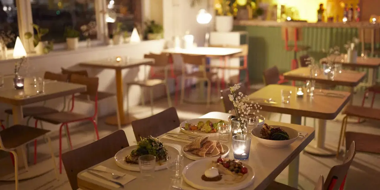 Gemütliche Tische mit Essen und Kerzenlicht im Blumental Berlin.