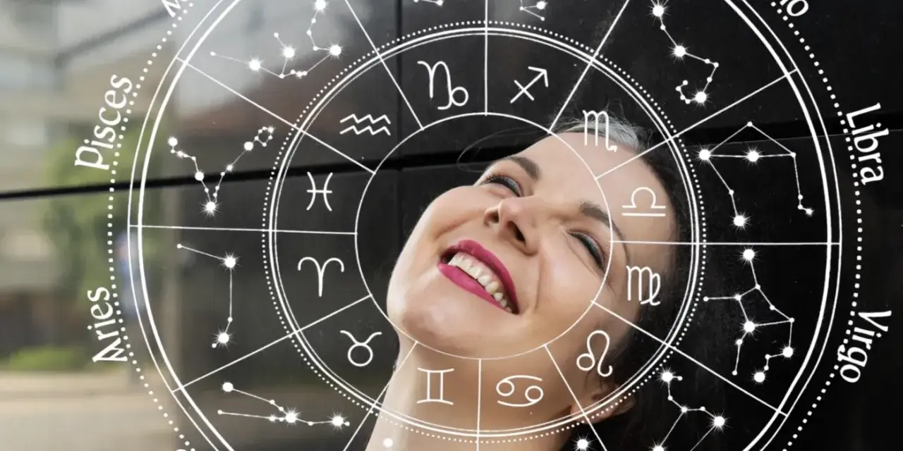 Uśmiechnięta kobieta wpatrzona w koło zodiaku. Sprawdź swój horoskop dzienny Baran i odkryj, co przyniesie Ci dzień!
