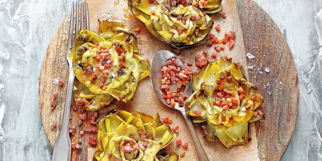 Deliciosas alcachofas al horno, doradas y rellenas de trocitos de jamón, listas para disfrutar.