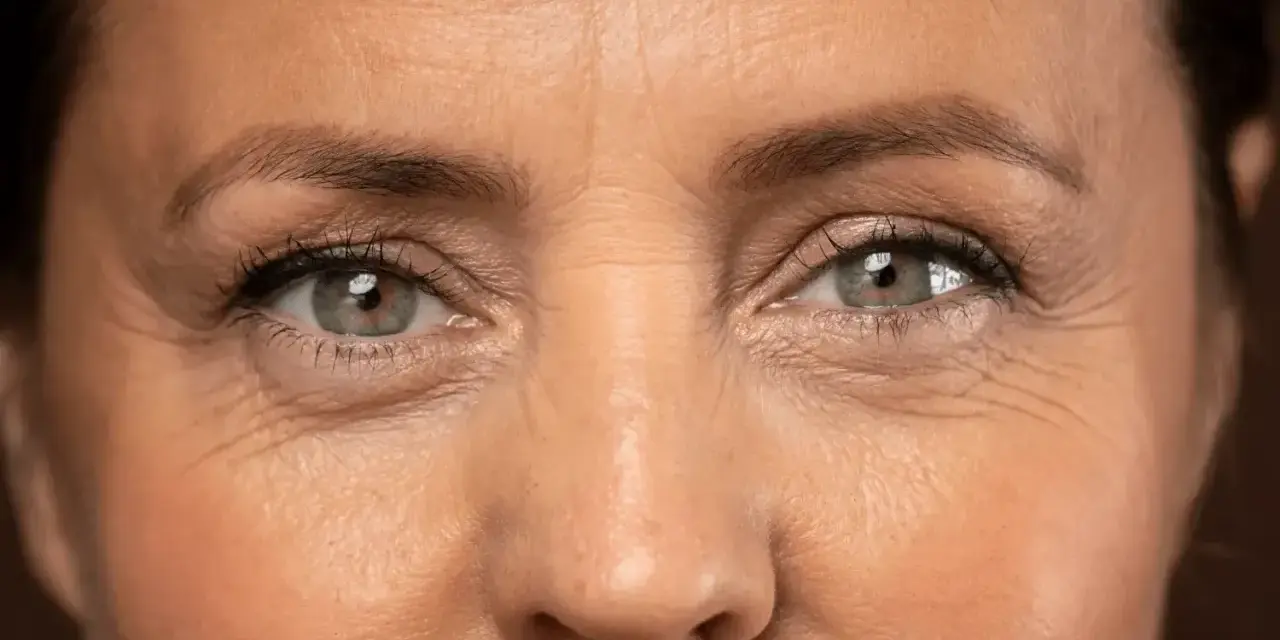 Primer plano de unos ojos con arrugas en los ojos a los 40, reflejando una vida de sonrisas y experiencias.