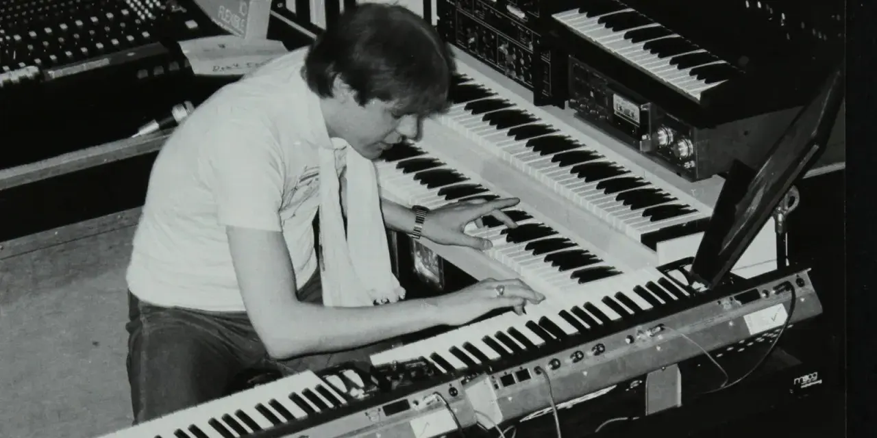 Mann spielt auf mehreren Synthesizern, die typische Klänge der 80er Jahre erzeugen.