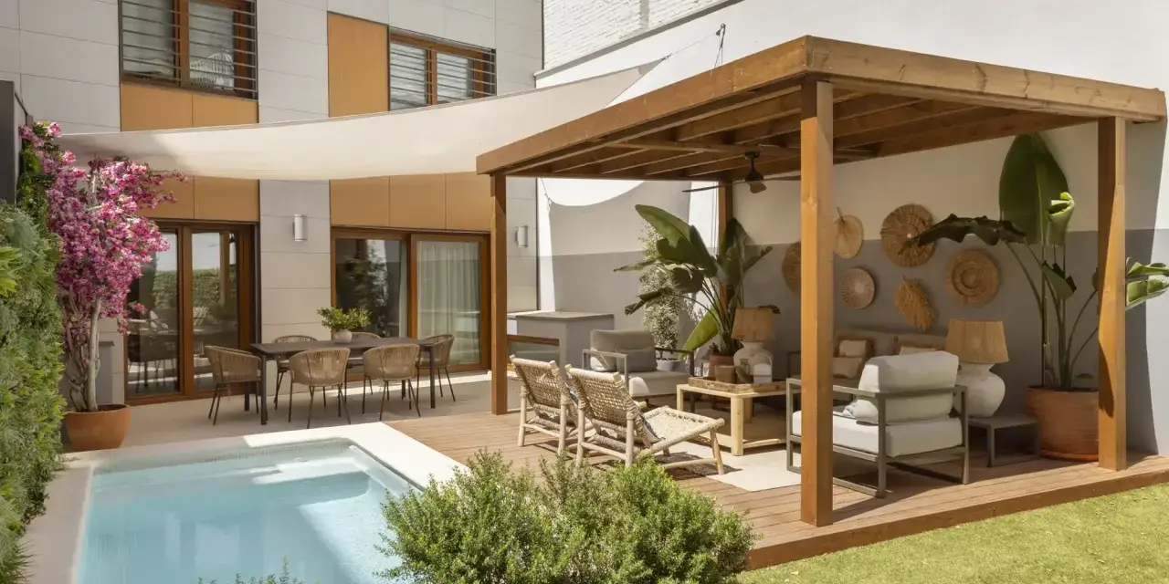 Modernos patios con piscina, zona de estar bajo pérgola de madera y comedor exterior.