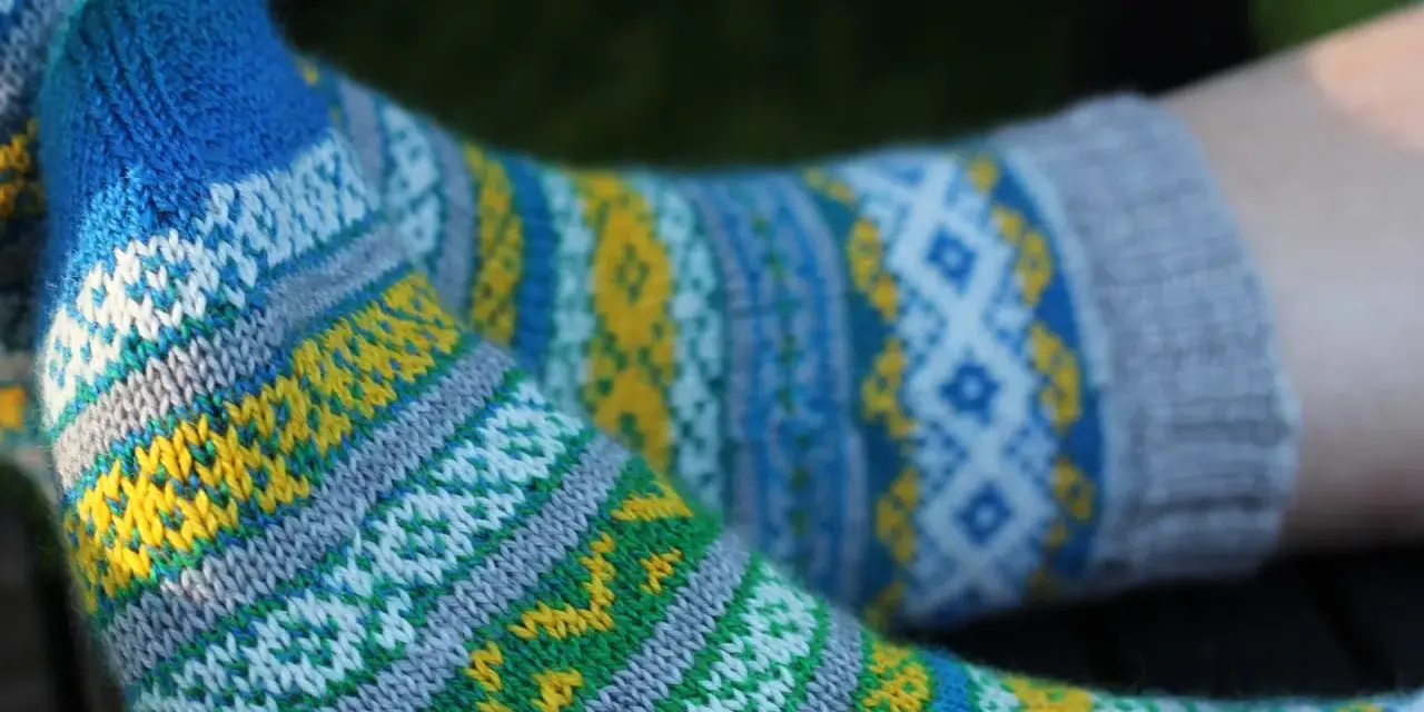 Två par stickade sockor med färgglatt sticka mönster med två färger i blått, gult, grönt och vitt.
