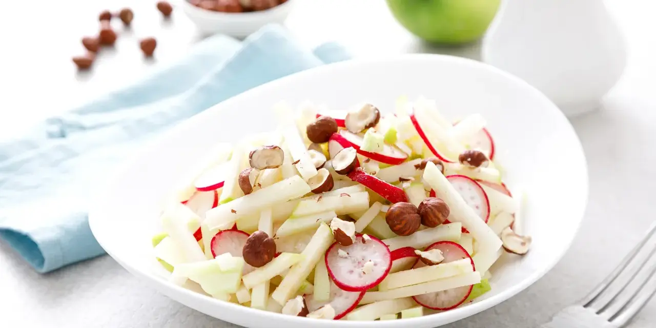 Frischer Kohlrabi Salat mit Radieschen und Haselnüssen, garniert mit Apfelstücken. Ein leichter Genuss!