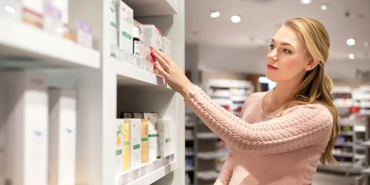 Ciężarna kobieta wybiera kosmetyki, szukając bezpiecznych produktów, np. bez kwasu salicylowego w ciąży.