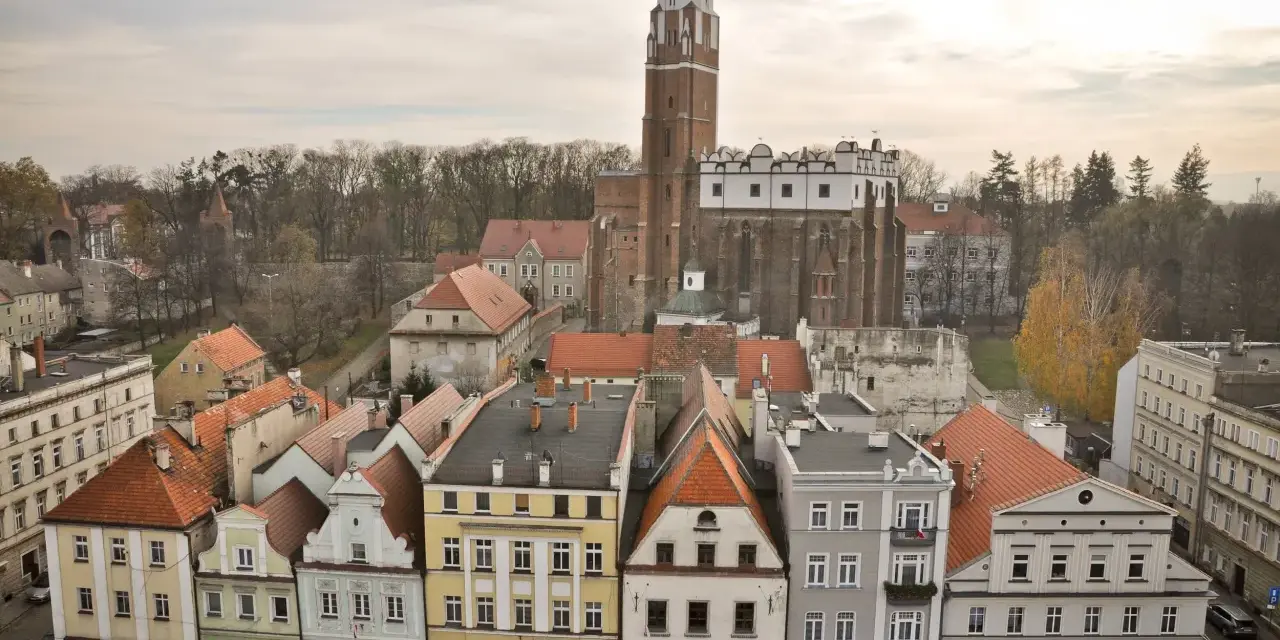 Widok na rynek i zamek w Paczkowie. Kolorowe kamieniczki i potężna wieża zamkowa tworzą niepowtarzalne paczków atrakcje.
