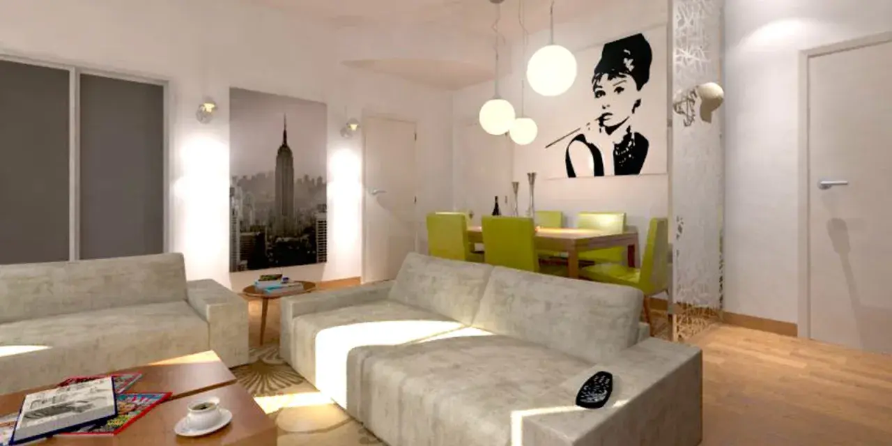 Un accogliente divano davanti alla porta finestra, con un quadro di Audrey Hepburn e una vista di New York.