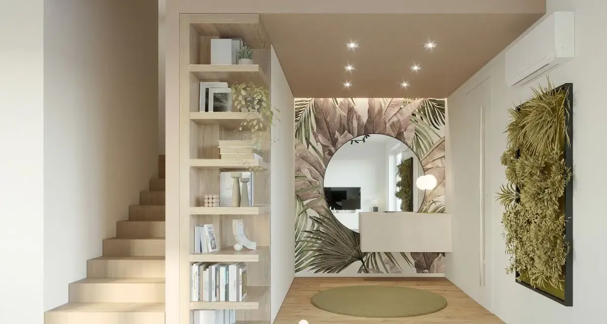 Ingresso ampio con libreria a giorno, scala in legno, specchio rotondo e carta da parati tropicale. Idee per come arredare un ingresso grande con stile.