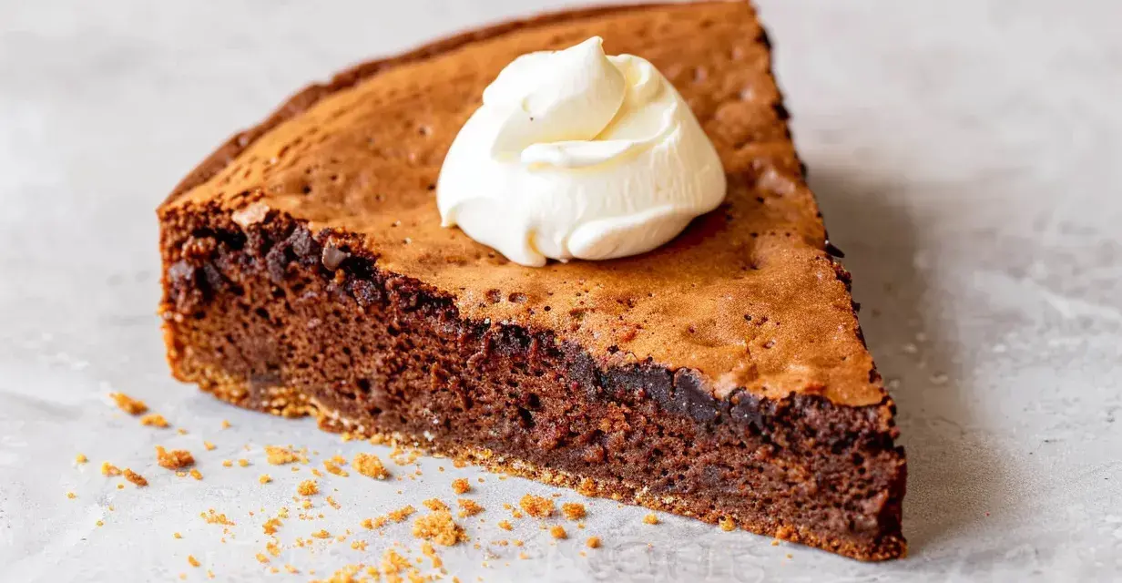 En bit kladdig protein kladdkaka med en klick vispad grädde.