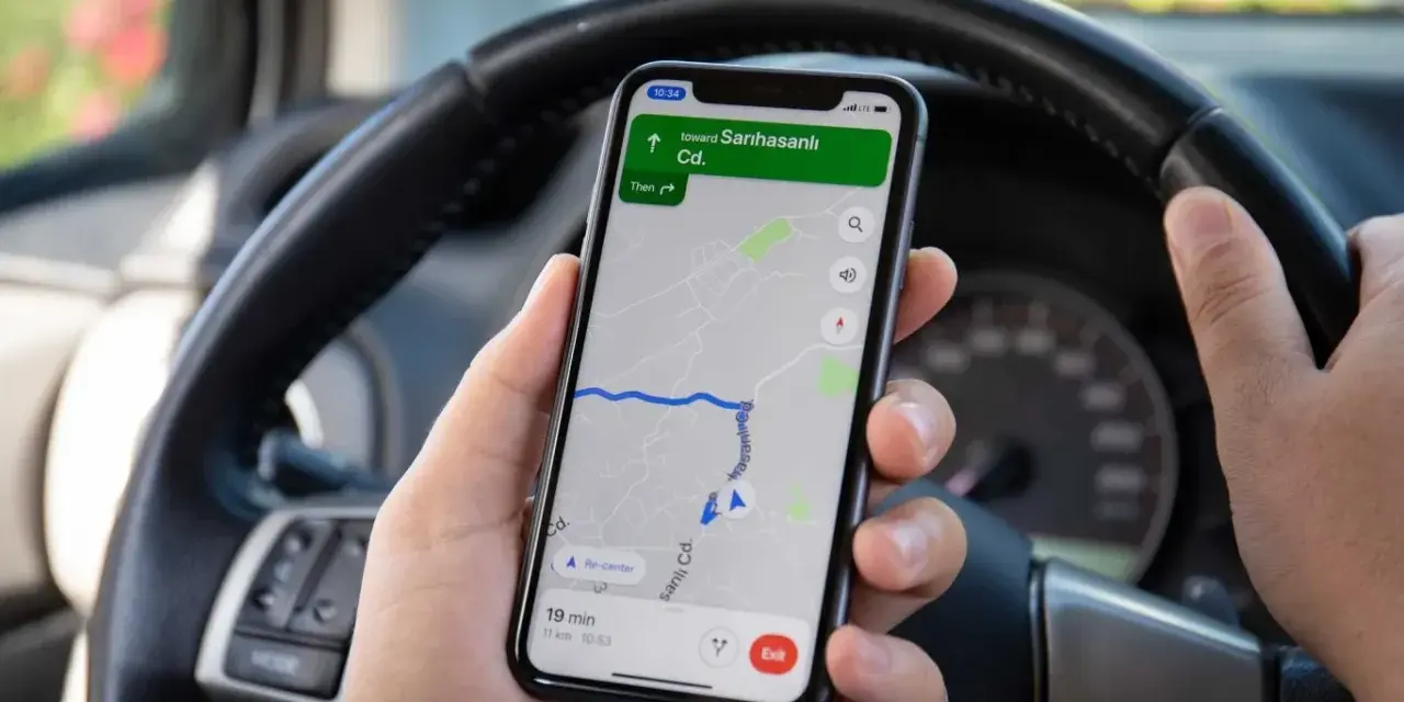 Dłoń trzyma telefon z nawigacją pokazującą trasę do Sarıhasanlı Cd. Czas dojazdu 19 minut. Ile punktów za telefon?