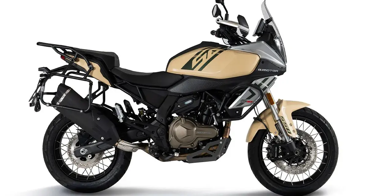 Beżowy motocykl turystyczny z bagażnikami, gotowy na dalekie wyprawy.