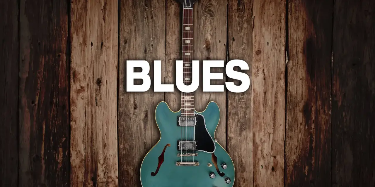 Eine teal-farbene E-Gitarre mit dem Wort "BLUES" darüber, auf rustikalem Holz Hintergrund.