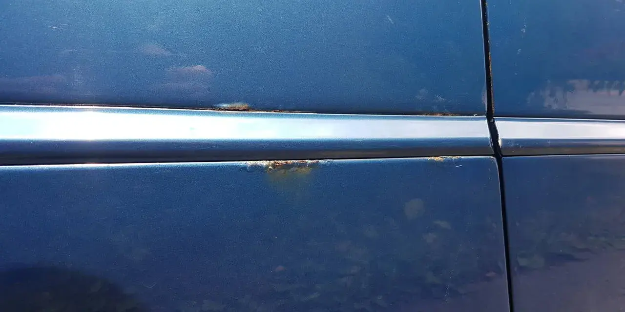Rostfläckar på blå bil. Dags att lacka om bilen innan det blir värre.