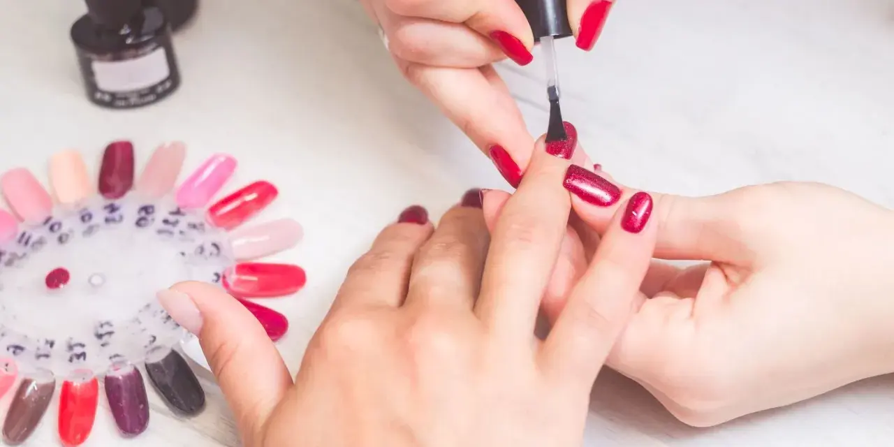 Manicure w czerwonym kolorze, idealny sposób na to, jak zapuścić paznokcie po obgryzaniu. Paleta kolorów lakierów do paznokci.