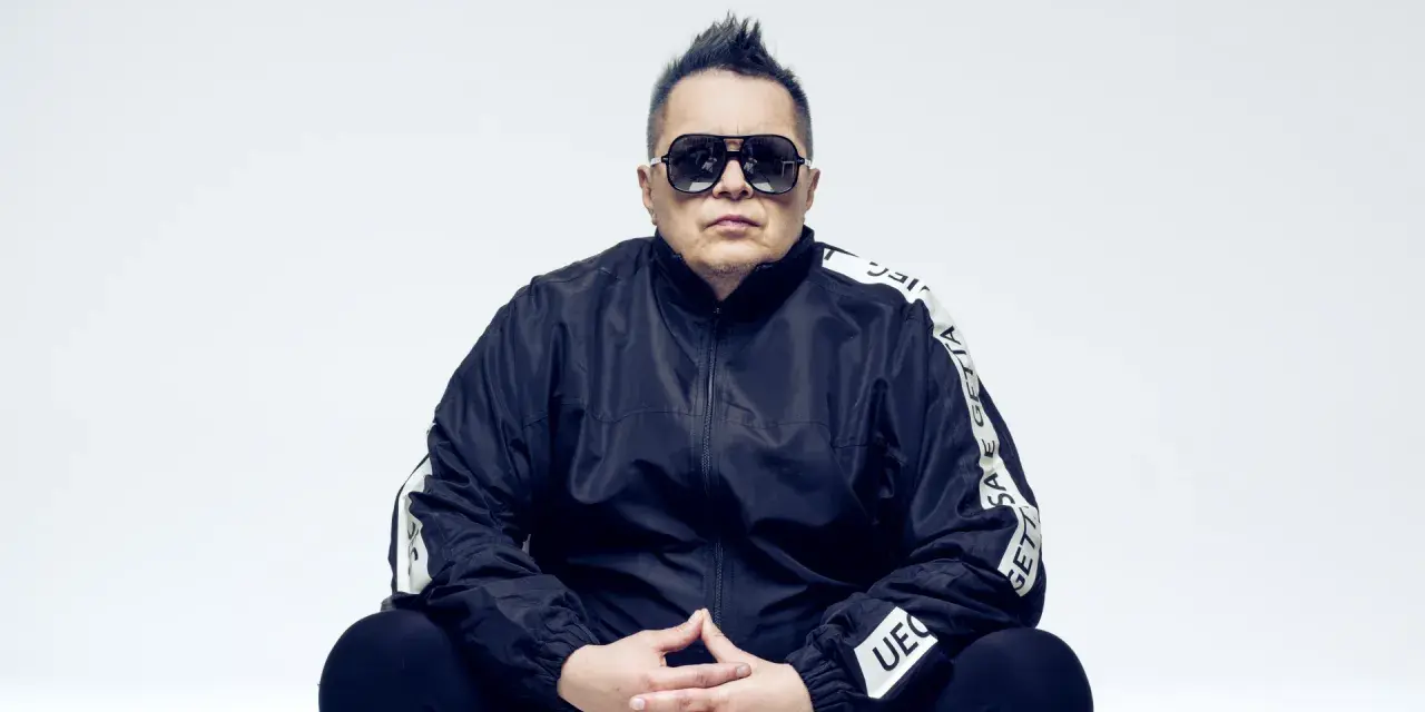 Marek "Mrozu" Mróz w okularach i czarnej kurtce z napisem "GETTA", jakby szykował się na koncert zespołu Munka Staszczyka.