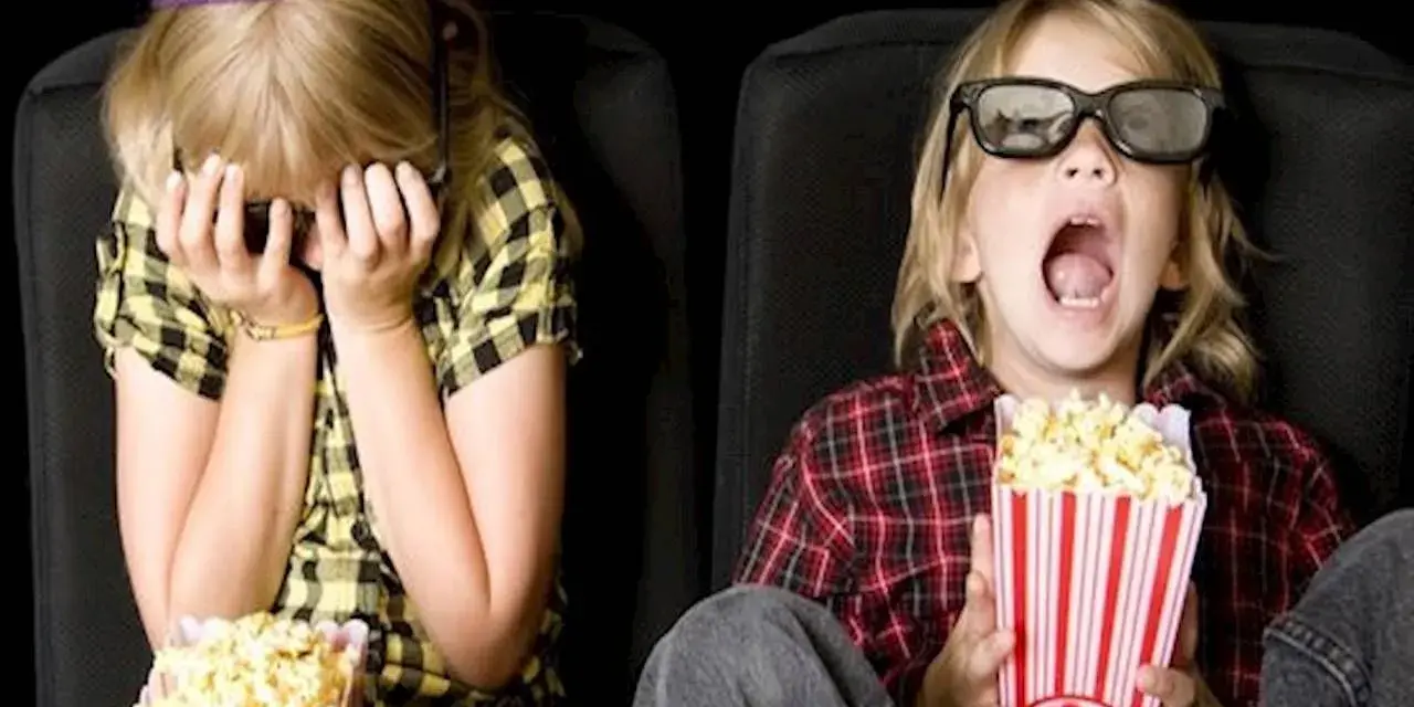 Dzieci w kinie, kiedy pierwszy raz do kina z dzieckiem. Jedno zakrywa twarz, drugie z popcornem w szoku.