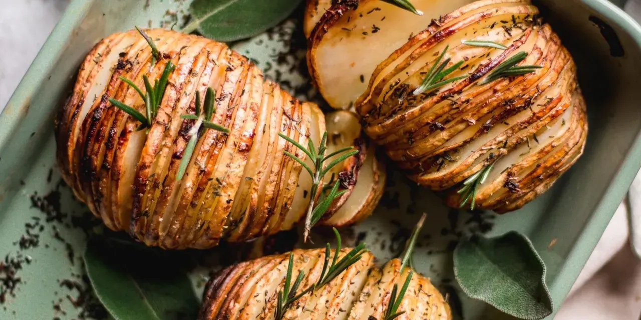Pommes de terre Hasselback dorées et croustillantes, garnies de romarin frais. Une recette pomme de terre parfaite pour accompagner vos plats.