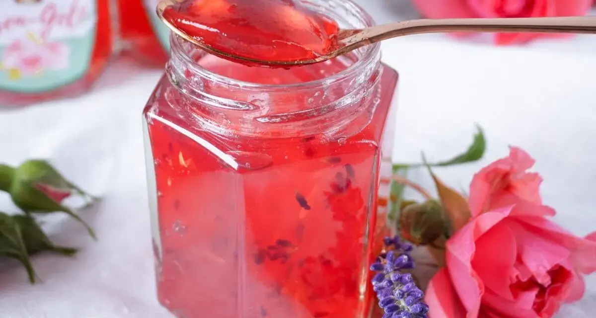 Ein Glas Sylter Rosenmarmelade, verziert mit Rosen und Lavendel. Ein köstliches Rezept für den Sommer.