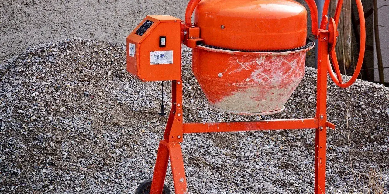Pomarańczowa betoniarka gotowa do pracy. Z jej pomocą szybko przygotujesz beton B25 na budowę.