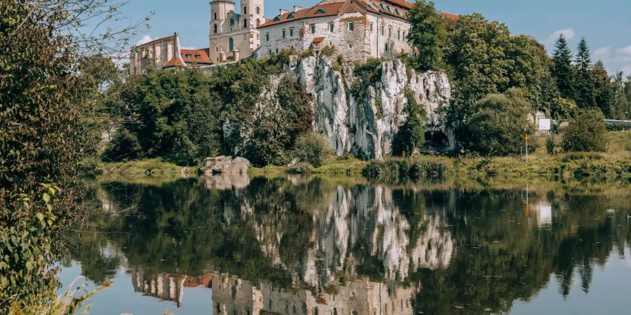 Opactwo Benedyktynów w Tyńcu, malowniczo położone na skale nad Wisłą, odbija się w spokojnej tafli rzeki. Tyniec Kraków.