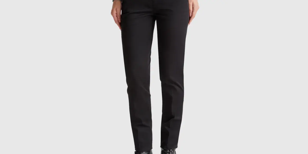 Mujer con pantalones chinos negros y botines gruesos. Un look moderno y versátil.