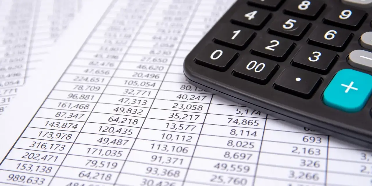 Calculadora sobre hoja de cuentas, mostrando posibles remuneraciones pendientes de pago activo o pasivo.