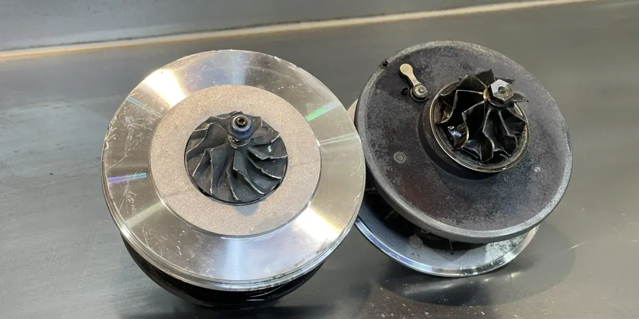 Due turbocompressori per motore, uno nuovo e uno usurato, pronti per un intervento.