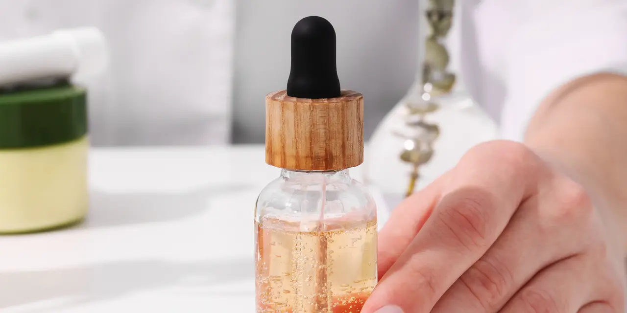 Dłoń trzymająca serum z pipetką. Składniki takie jak EDTA w kosmetykach pomagają stabilizować formuły.