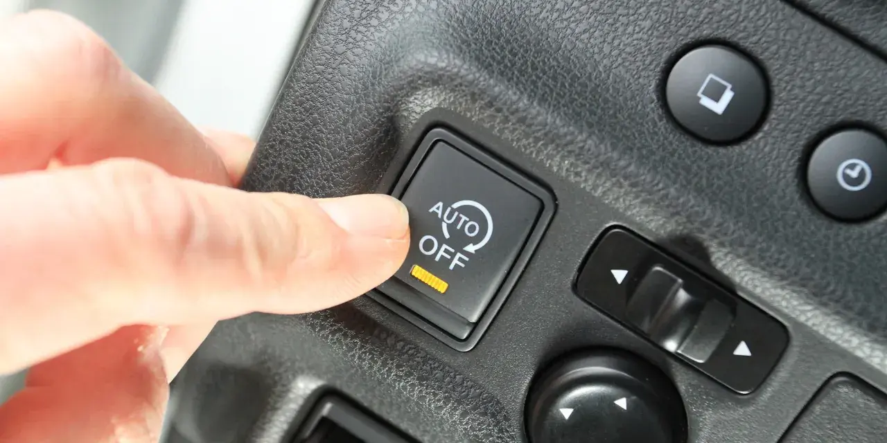 Palec naciska przycisk "AUTO OFF", wyłączając system start-stop.