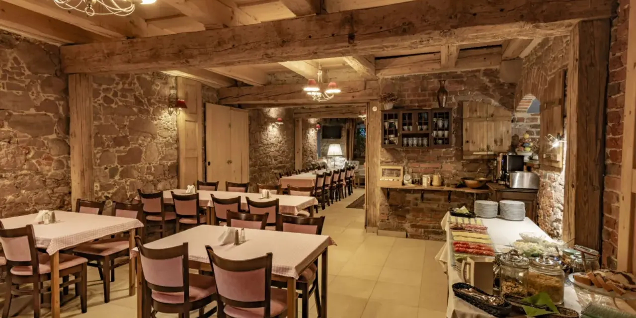 Przytulna restauracja w stylu rustykalnym, z kamiennymi ścianami i drewnianymi belkami. Idealne miejsce na posiłek w twierdzy Srebrna Góra.