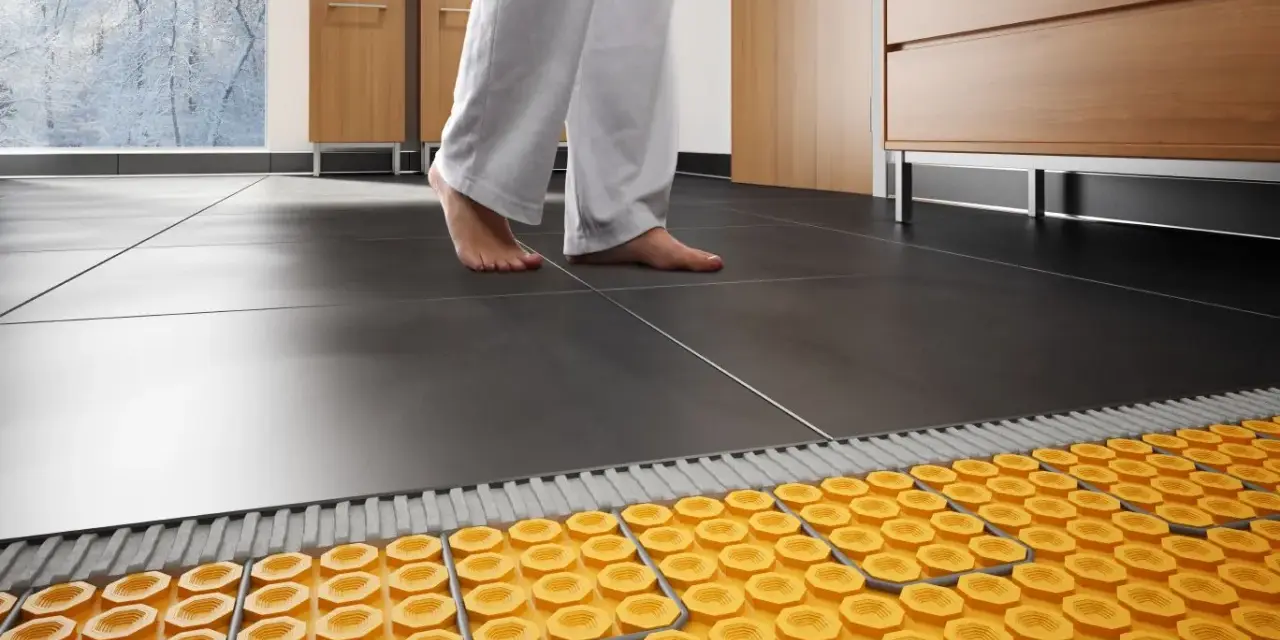 Piedi nudi su un pavimento piastrellato, con un sistema di riscaldamento ad aria calda visibile sotto.