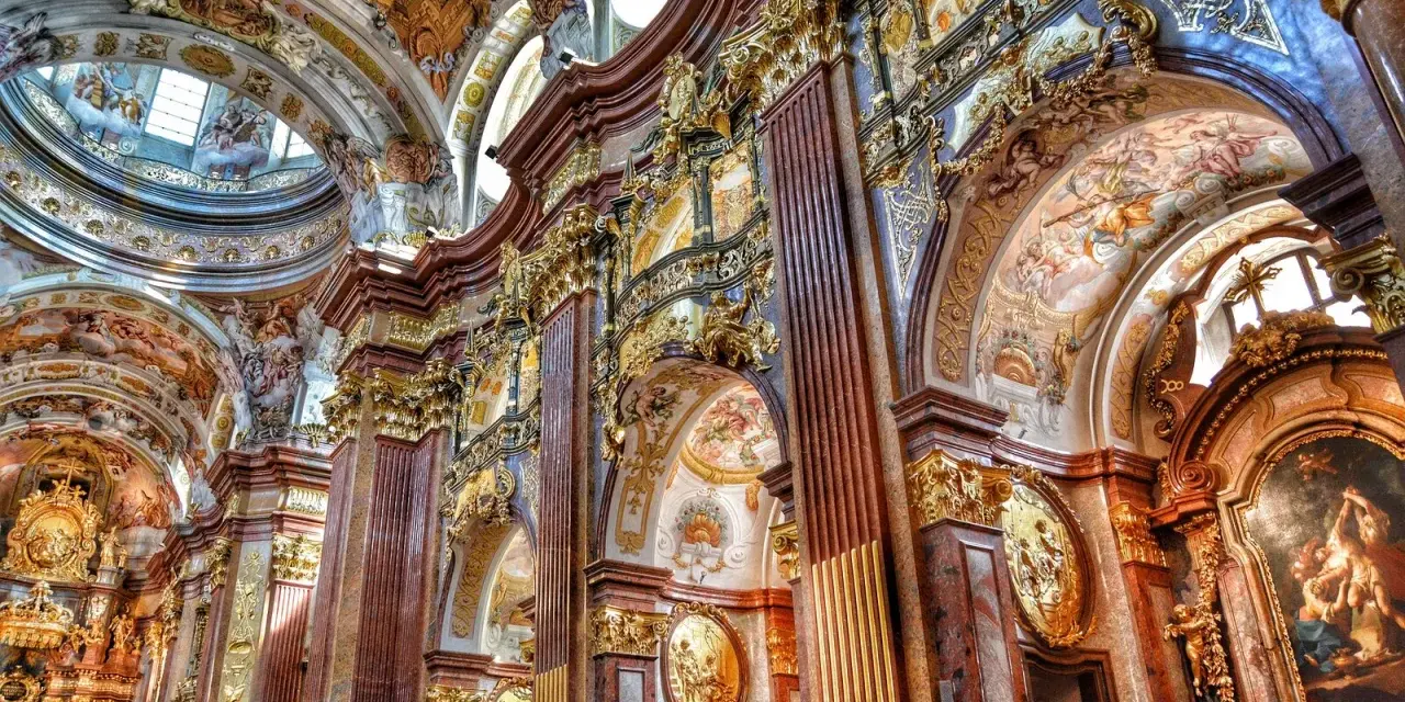 Bogata architektura baroku zachwyca złotymi zdobieniami, marmurowymi kolumnami i freskami na sklepieniach.