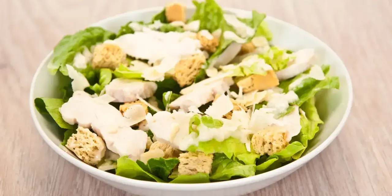 Salade César appétissante avec poulet, croûtons dorés et copeaux de parmesan. Un classique des salade cesar ingredient.