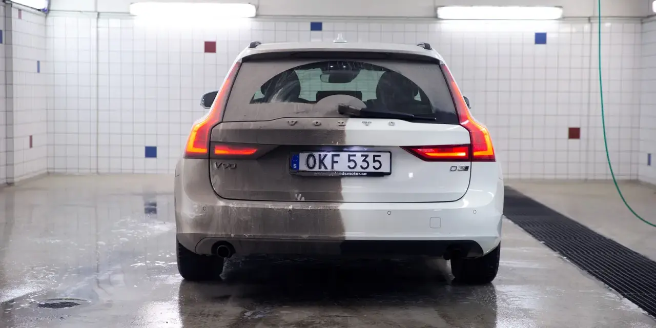 Volvo V90, halvtvättad. En sida är täckt av lera, den andra skiner efter avfettning bil.