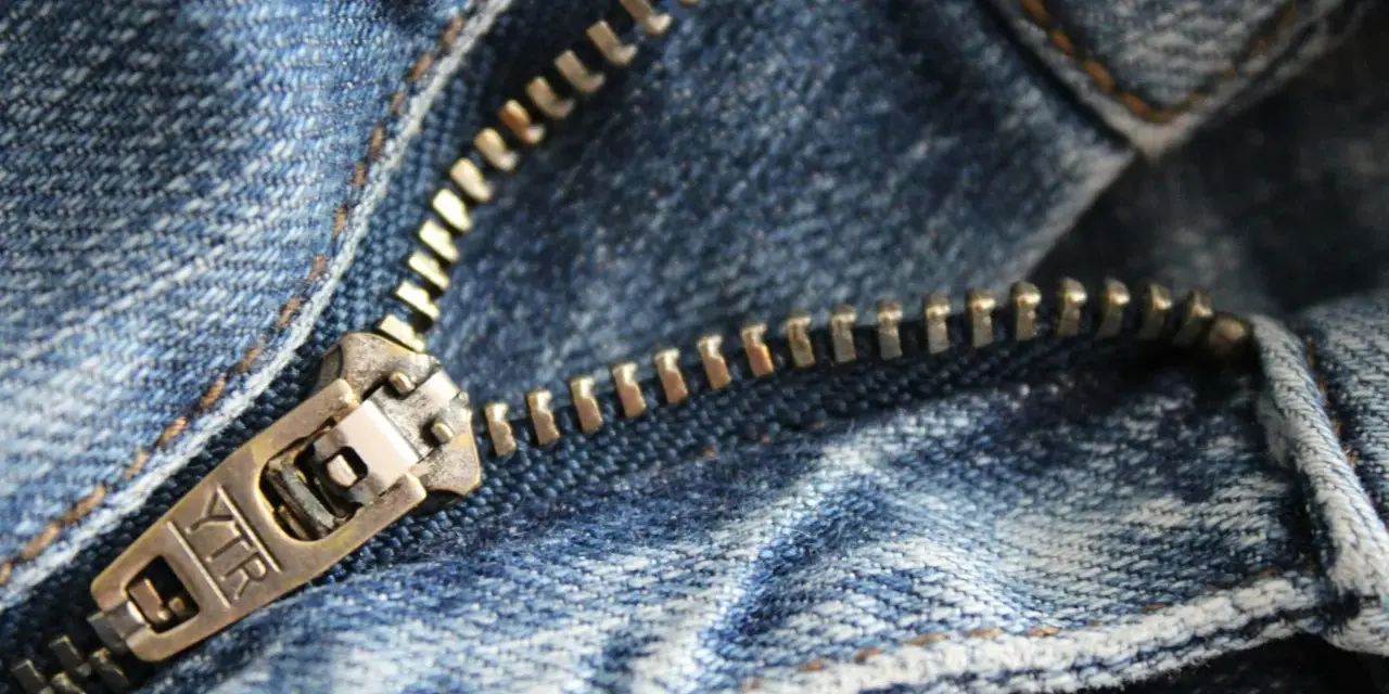Primer plano de una cremallera de jeans. Aprende como arreglar una cremallera rota para que tus pantalones vuelvan a funcionar.