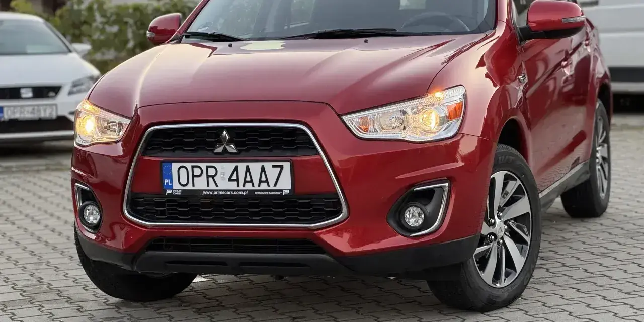Czerwone Mitsubishi ASX z przodu, z tablicą rejestracyjną OPR 4AA7.