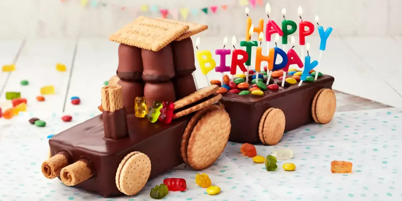 Schokoladen-Traktor-Torte, die man leicht selber machen kann, mit bunten Kerzen und Gummibärchen verziert.