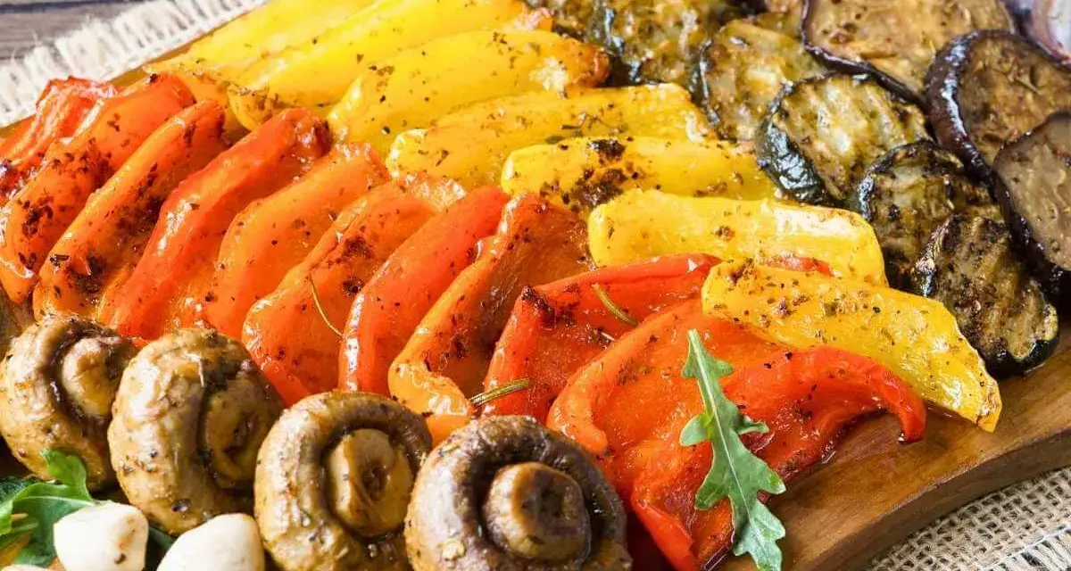 Eine bunte fingerfood antipasti platte mit gegrilltem Gemüse: Paprika, Zucchini, Auberginen und Champignons, appetitlich gewürzt.