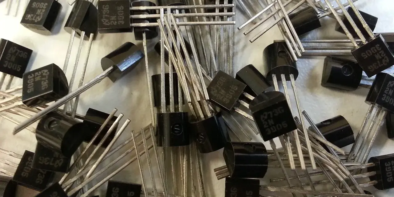 Mnóstwo czarnych tranzystorów 2N3905, każdy z trzema nóżkami. To właśnie tranzystor co to jest, mały, ale ważny element elektroniczny.