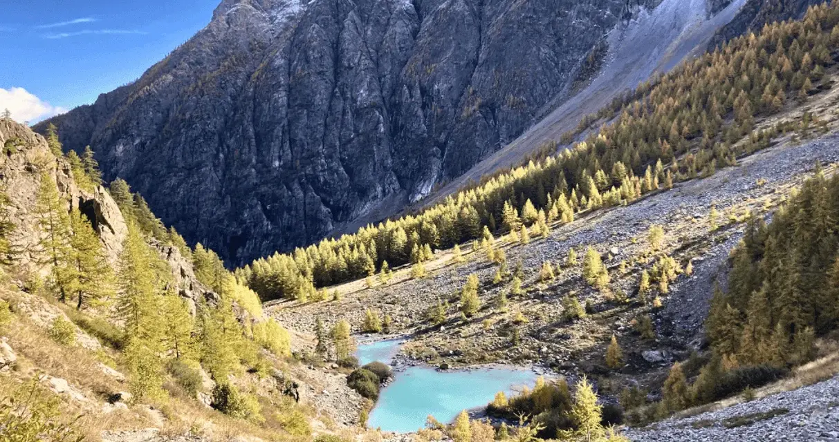 Magnifique lac turquoise au cœur d'une vallée alpine aux couleurs d'automne, parfait pour un tour des Écrins 10 jours.
