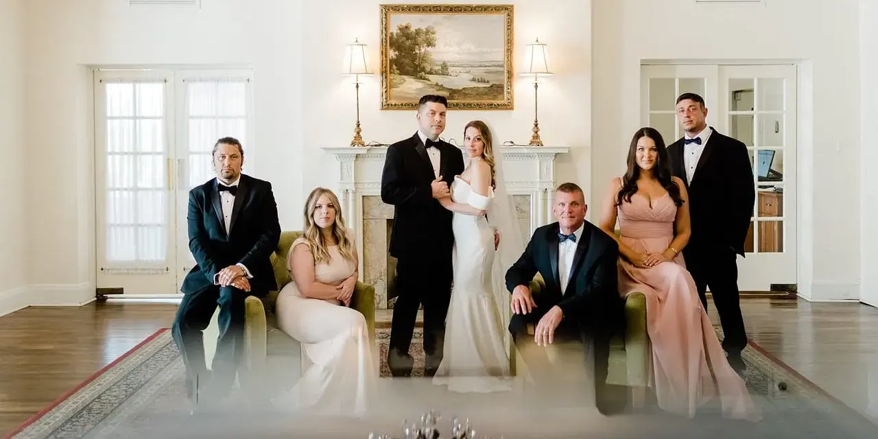 Para ślubna i drużba stoją w eleganckim wnętrzu.