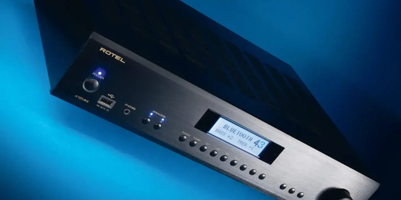 Czarny wzmacniacz Rotel A12 MKII z niebieskim podświetleniem, wyświetlaczem Bluetooth i pokrętłem głośności.