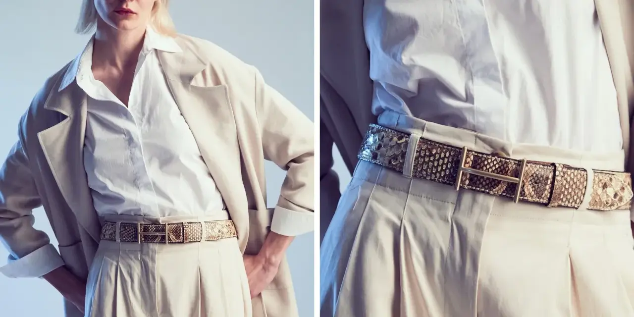 Modello indossa una cintura in pelle di serpente, un accessorio di tendenza che completa un look elegante con pantaloni beige e blazer.