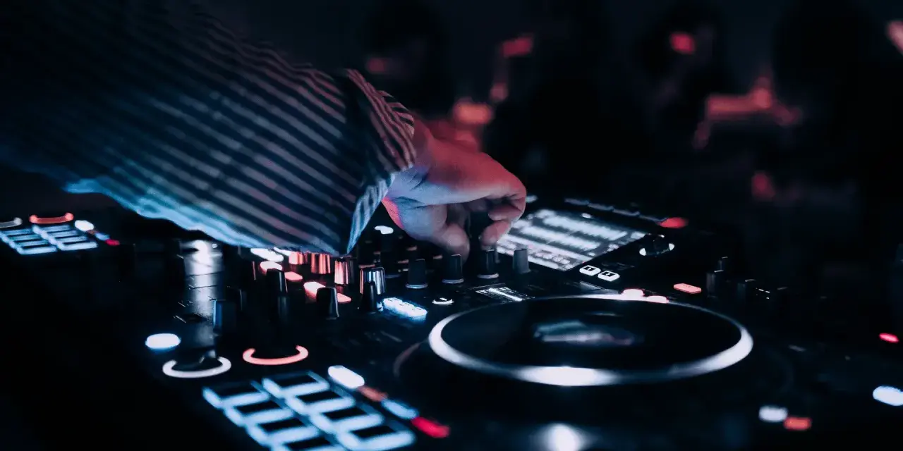 DJ przy konsoli, tworzy muzykę na weselu. Zastanawiasz się, ile zarabia dj na weselu?