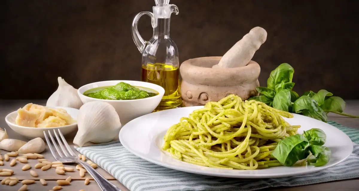 Pyszny makaron z pesto ze słoika, podany z bazylią, czosnkiem, parmezanem i orzeszkami pinii.