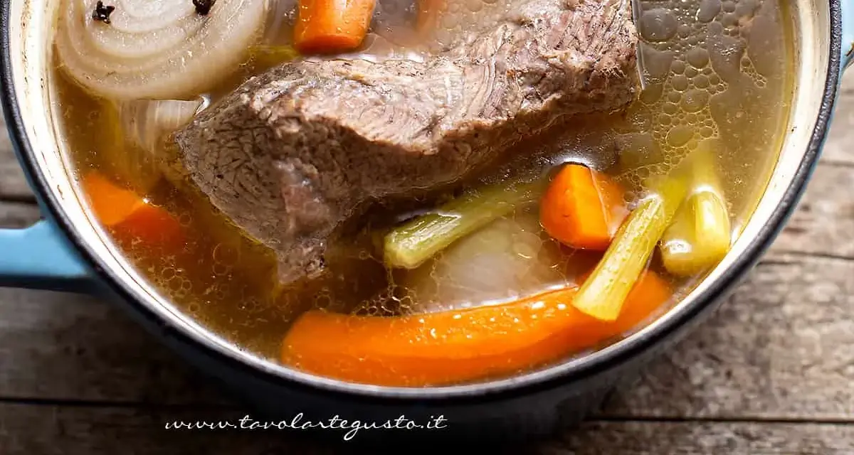 Un pezzo di carne succulenta cuoce lentamente in un brodo di carne ricco, con carote, sedano e cipolla.