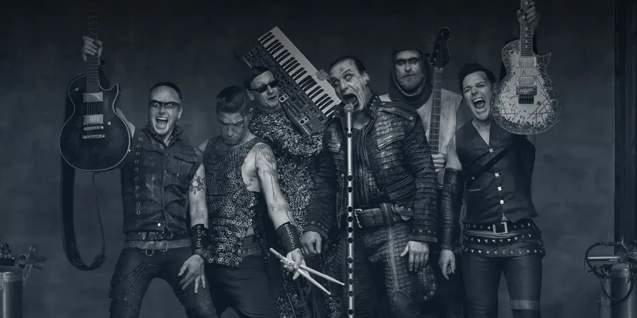 Rammstein-Bandmitglieder mit Instrumenten, schwarz-weiß.