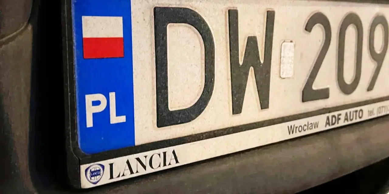 Tablica rejestracyjna z napisem "DW 209" i flagą Polski. Zsd rejestracja Lancia z Wrocławia.